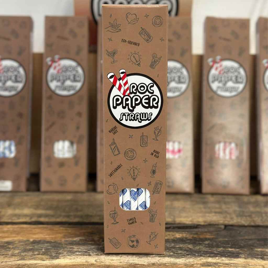 Packaged straws with 'Roc Paper Straw' branding on a wooden surface.
