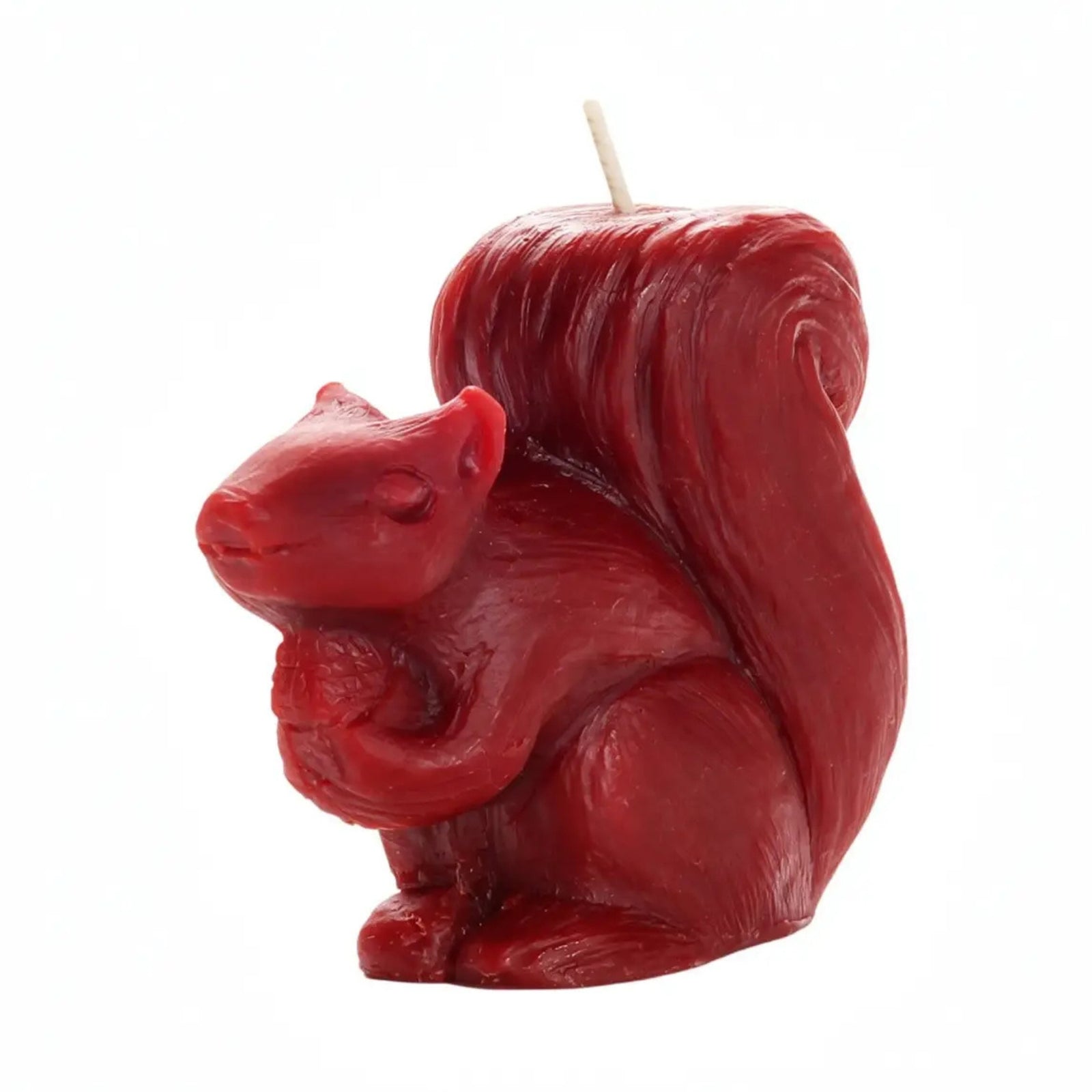 A red squirrel-shaped candle with a sculpted body, large curled tail, and a single wick on a plain white background.