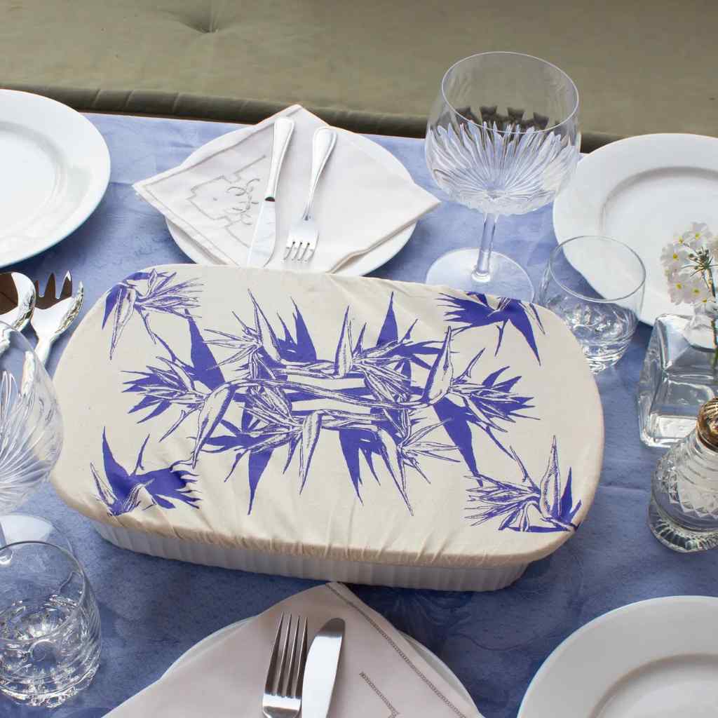 Rectangular dish cover with blue floral pattern on a table setting with plates, glasses, and cutlery.