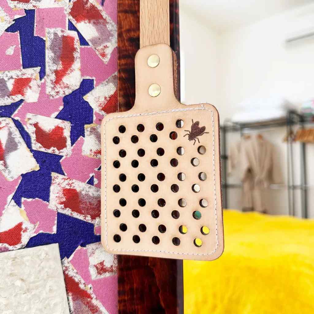 Fly swatter with a colorful abstract pattern in the background