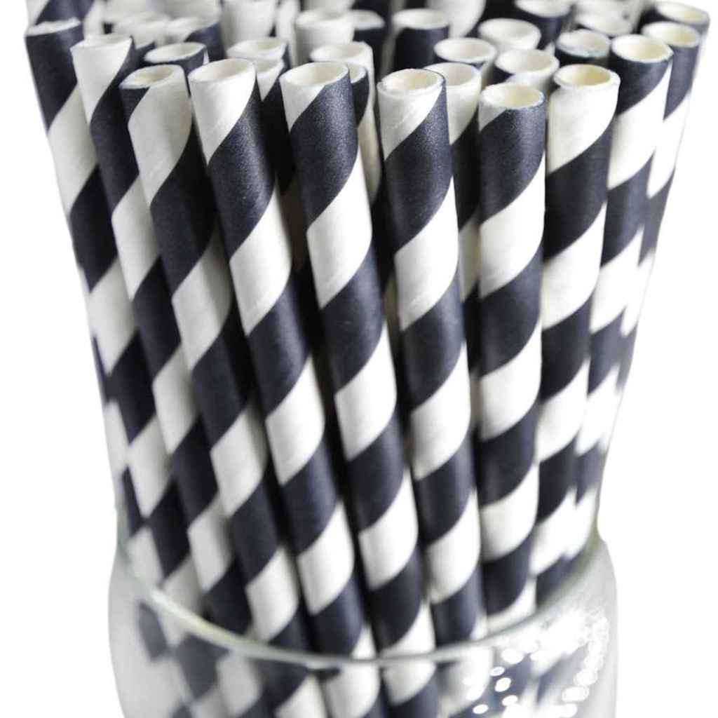 White and black striped paper straws in a clear container.
