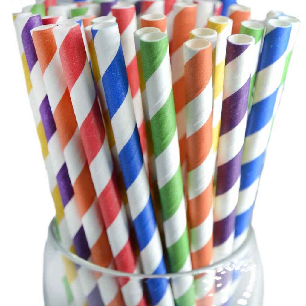 A glass filled with colorful biodegradable paper straws featuring a multicolored dot pattern.