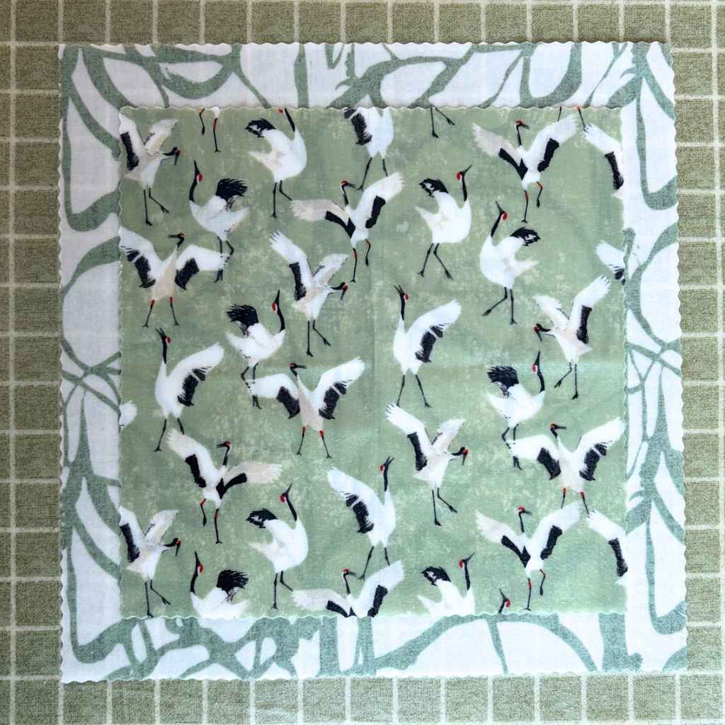 Beeswax squares with crane pattern on a green and white geometric background.