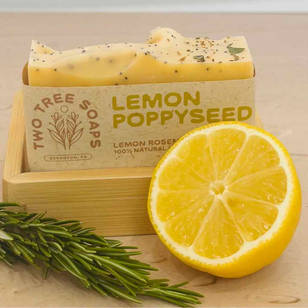 Two Tree Soaps Lemon Poppyseed soap bar with a lemon and rosemary on a wooden surface