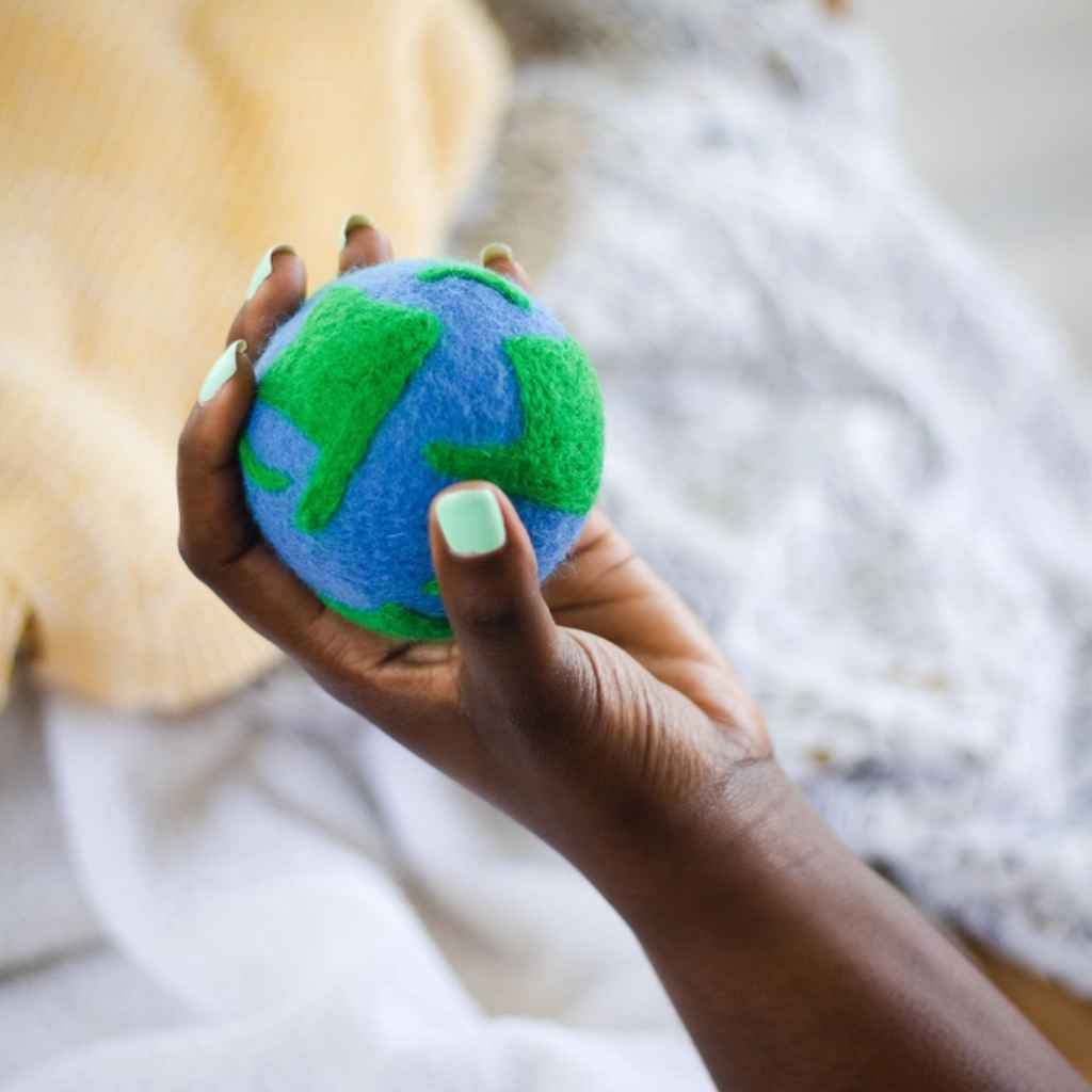 Single wool dryer ball designed to look like the earth in blue and green. Made by Friendsheep