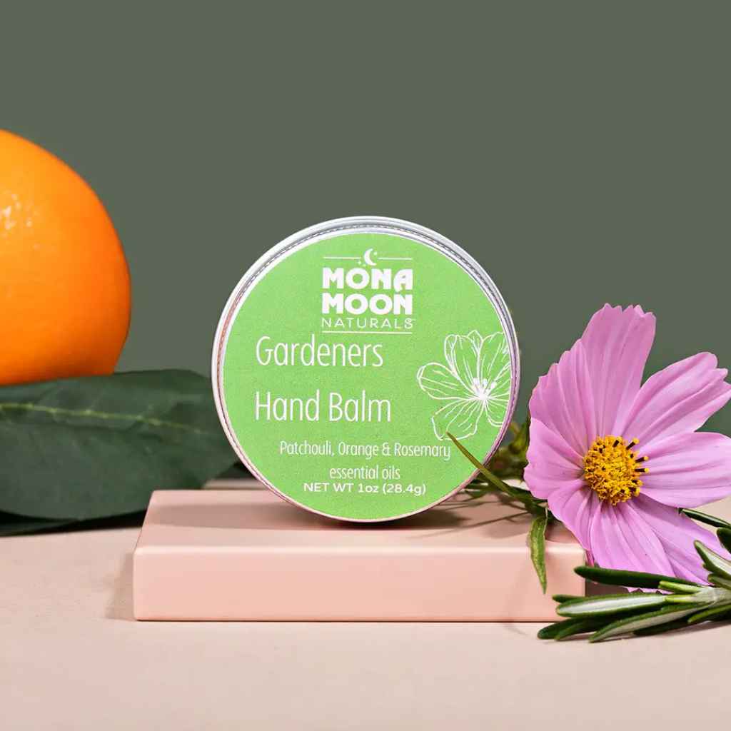 Mona Moon Naturals Hand Balm in Gardeners scent, a blend of patchouli, sweet orange, and rosemary, in 1oz recyclable tin. Made in Rochester, NY, USA.