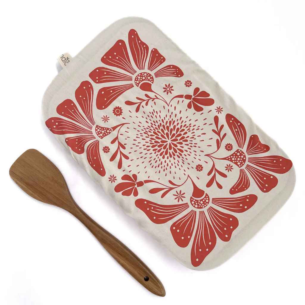 Rectangular dish cover with red floral pattern and wooden spatula on a white background