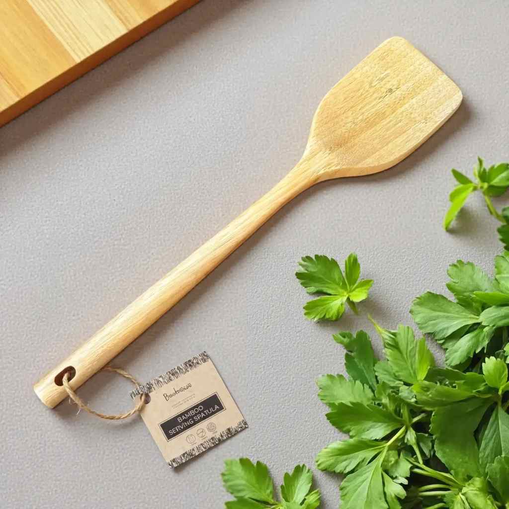 Wood spatula on counter with herbs.