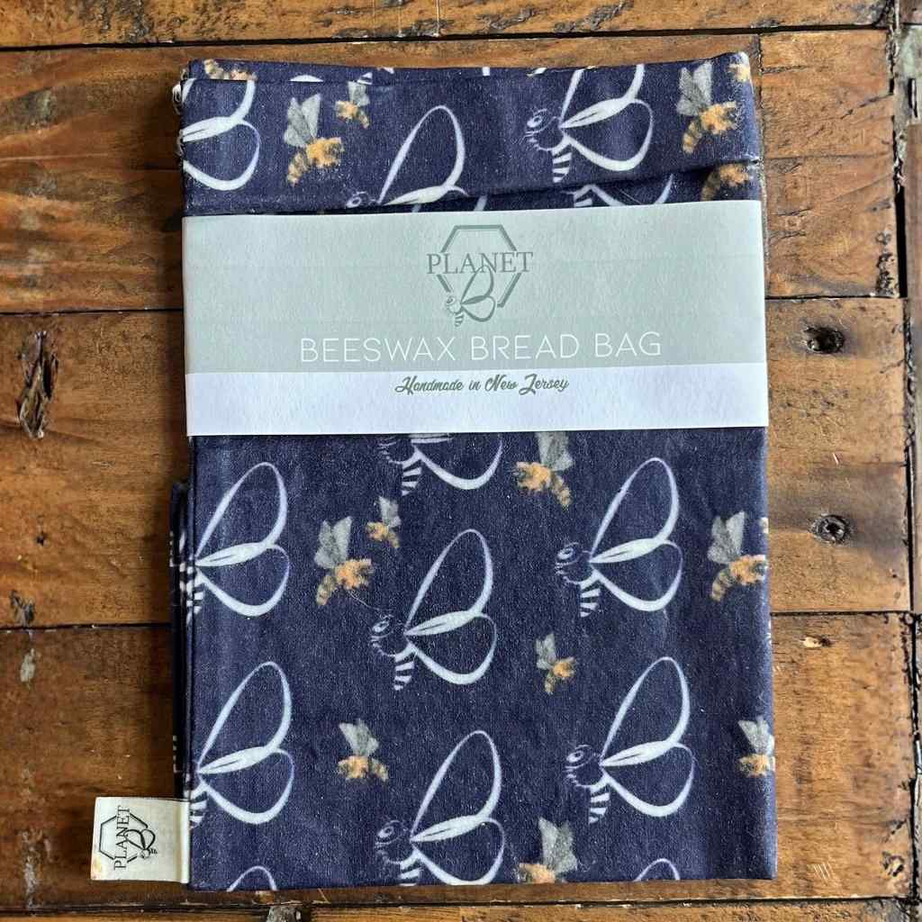 Beeswax bread bag with bee pattern on a wooden surface