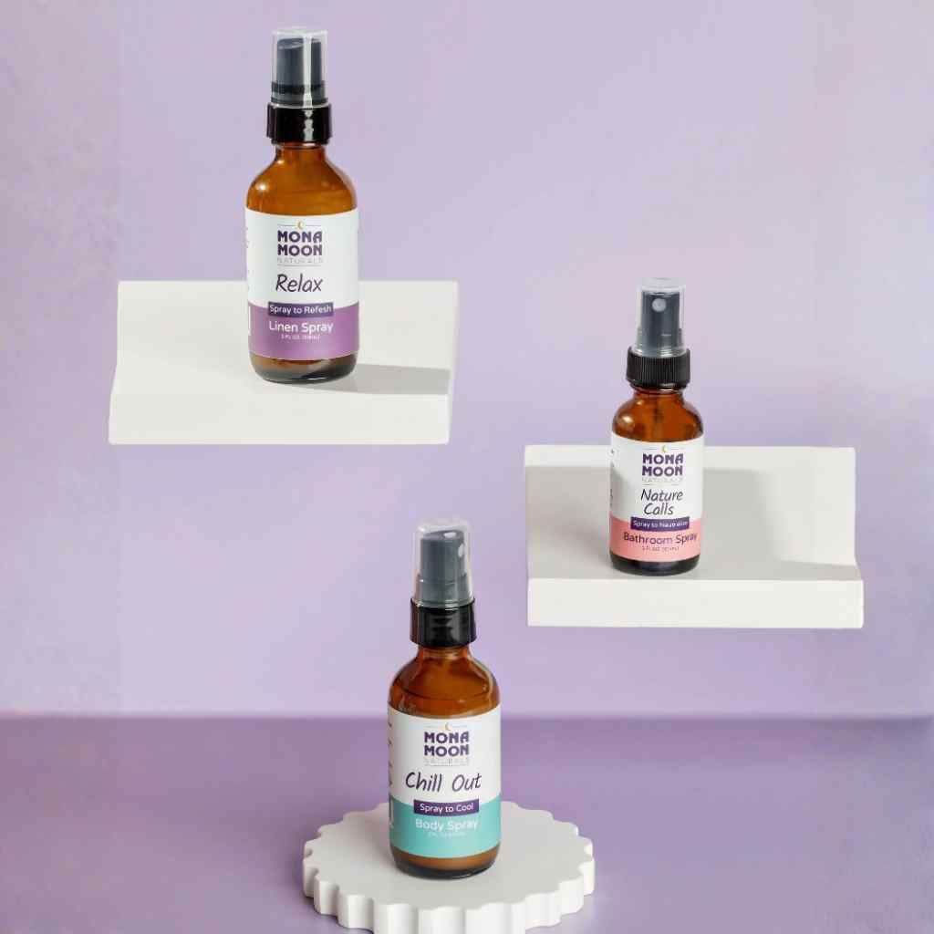 Three bottles of Mona Moon wellness spray products on a white stand against a purple background