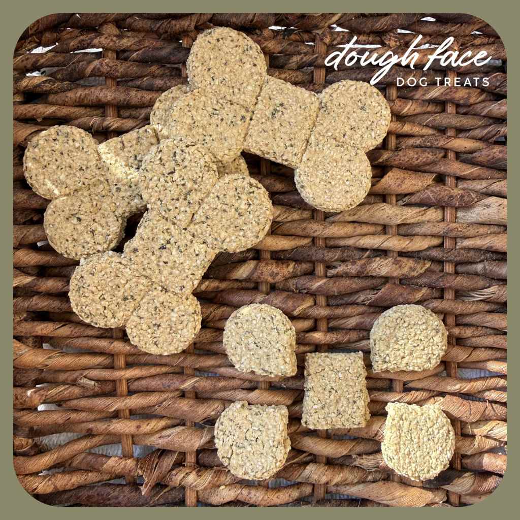 Dog treats shaped like bones on a wicker surface with 'dough face' branding.