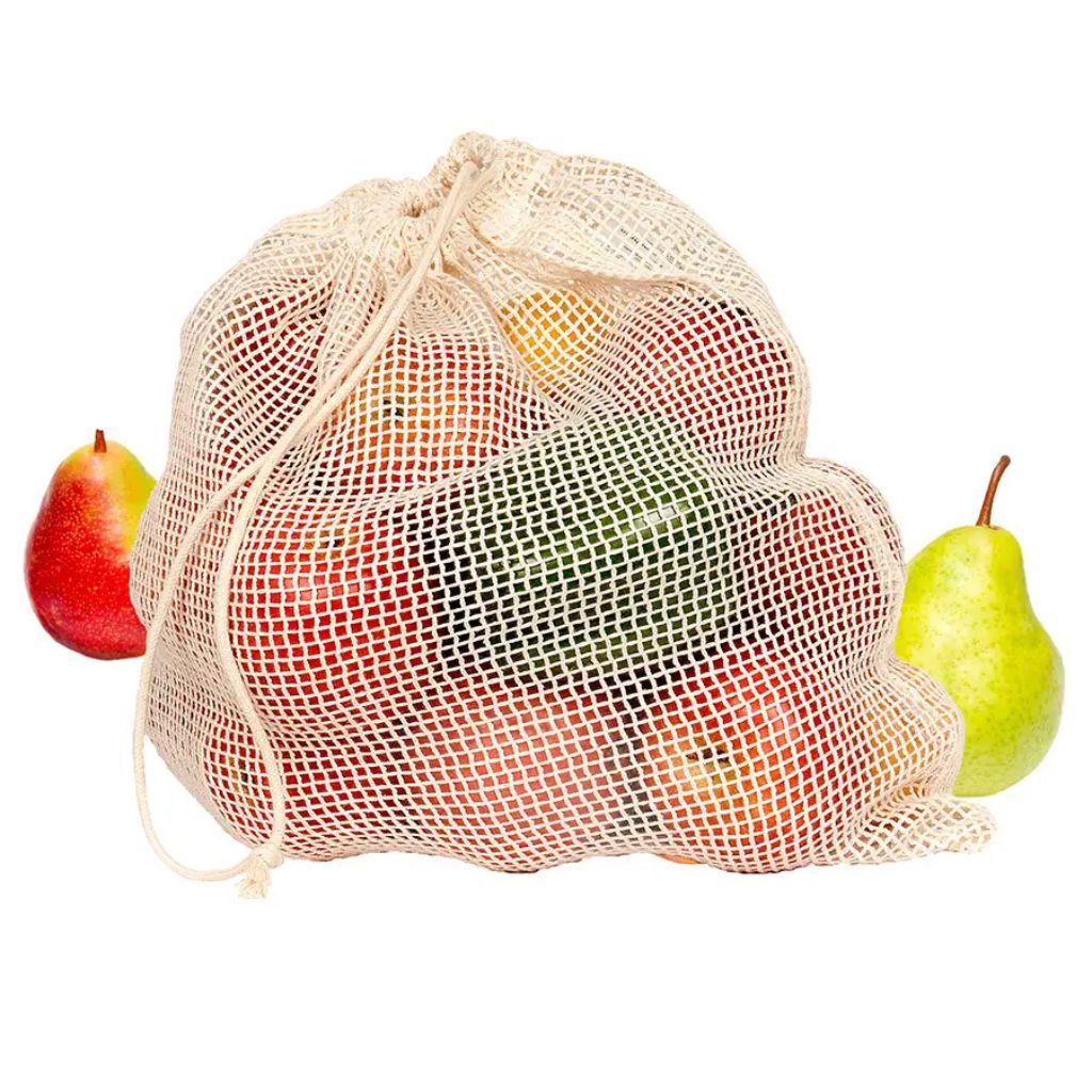 A natural beige cotton mesh drawstring bag filled with assorted fruits, shown on a white background with a red apple on the left and a green pear on the right.
