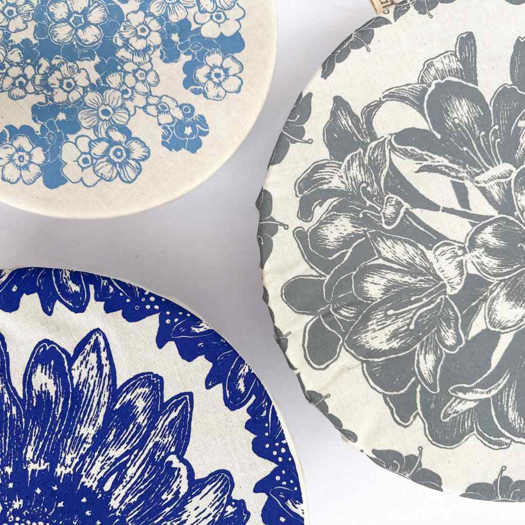 Three organic cotton floral patterned dish covers on a white background
