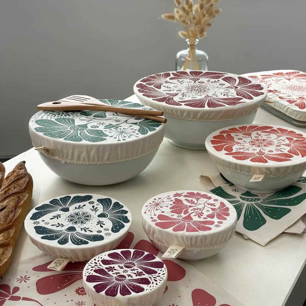 Set of decorative bowl covers with floral patterns on a table.