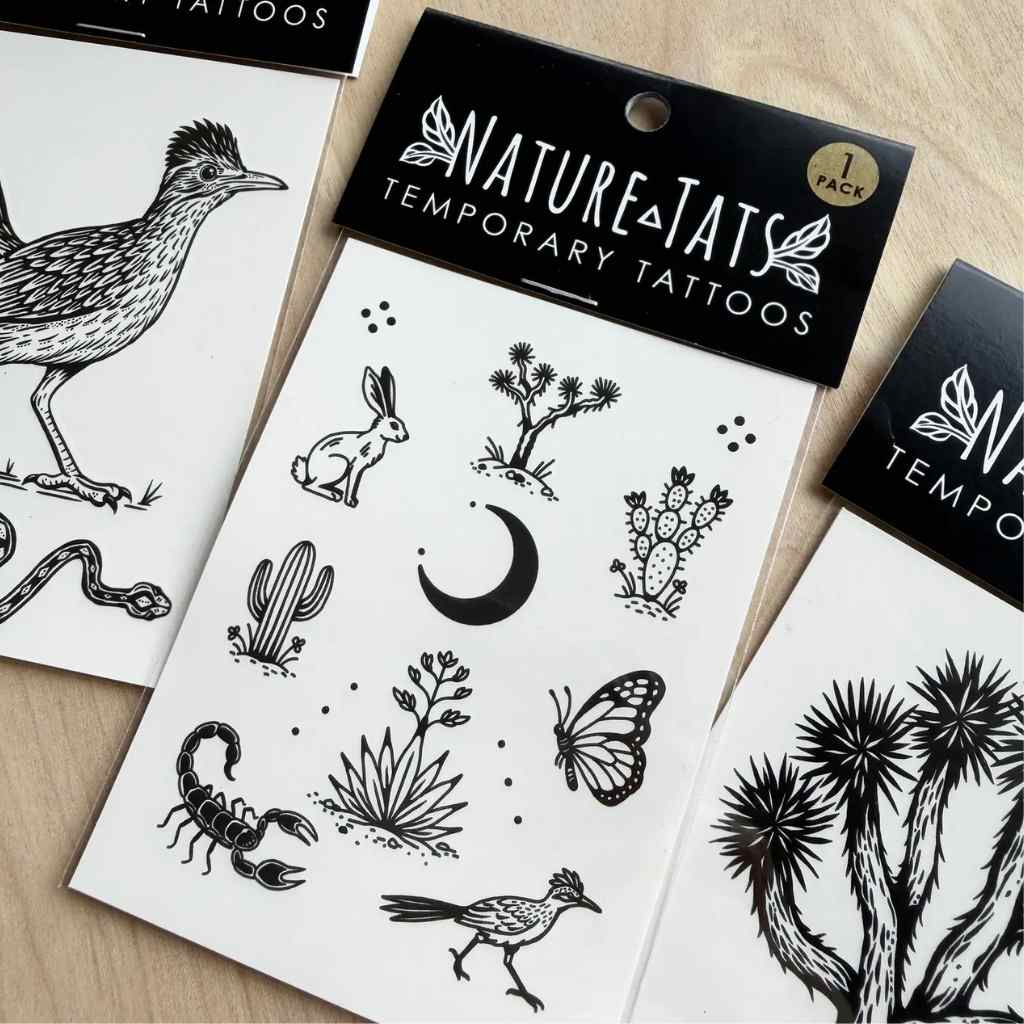 Naturetats temporary tattoos with wildlife and plant designs on a wooden surface.