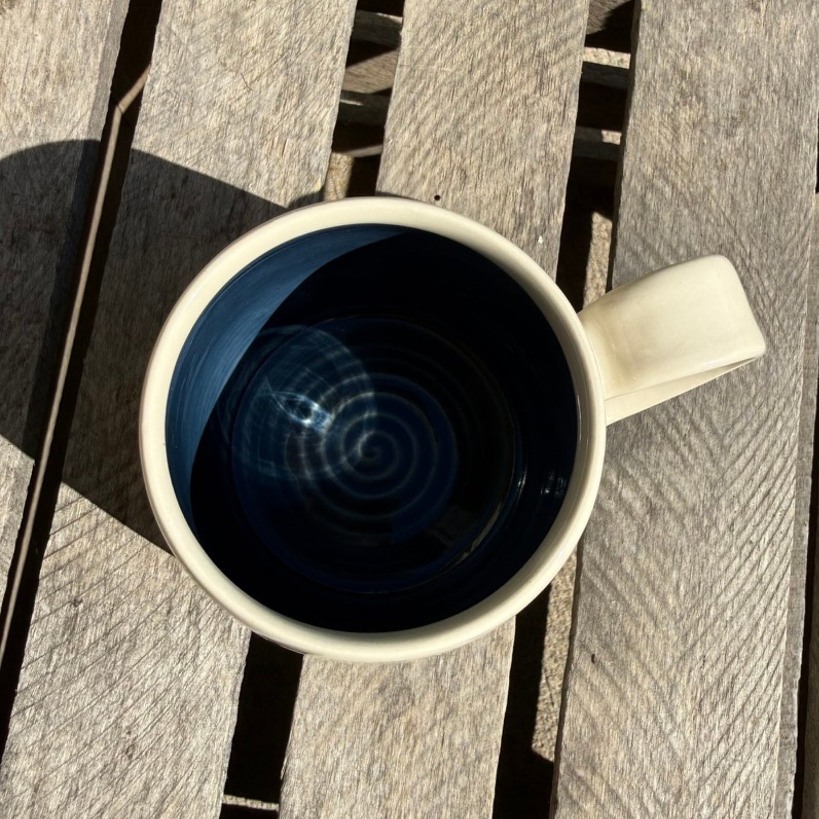 Top view looking into blue colored mug on wood crate.
