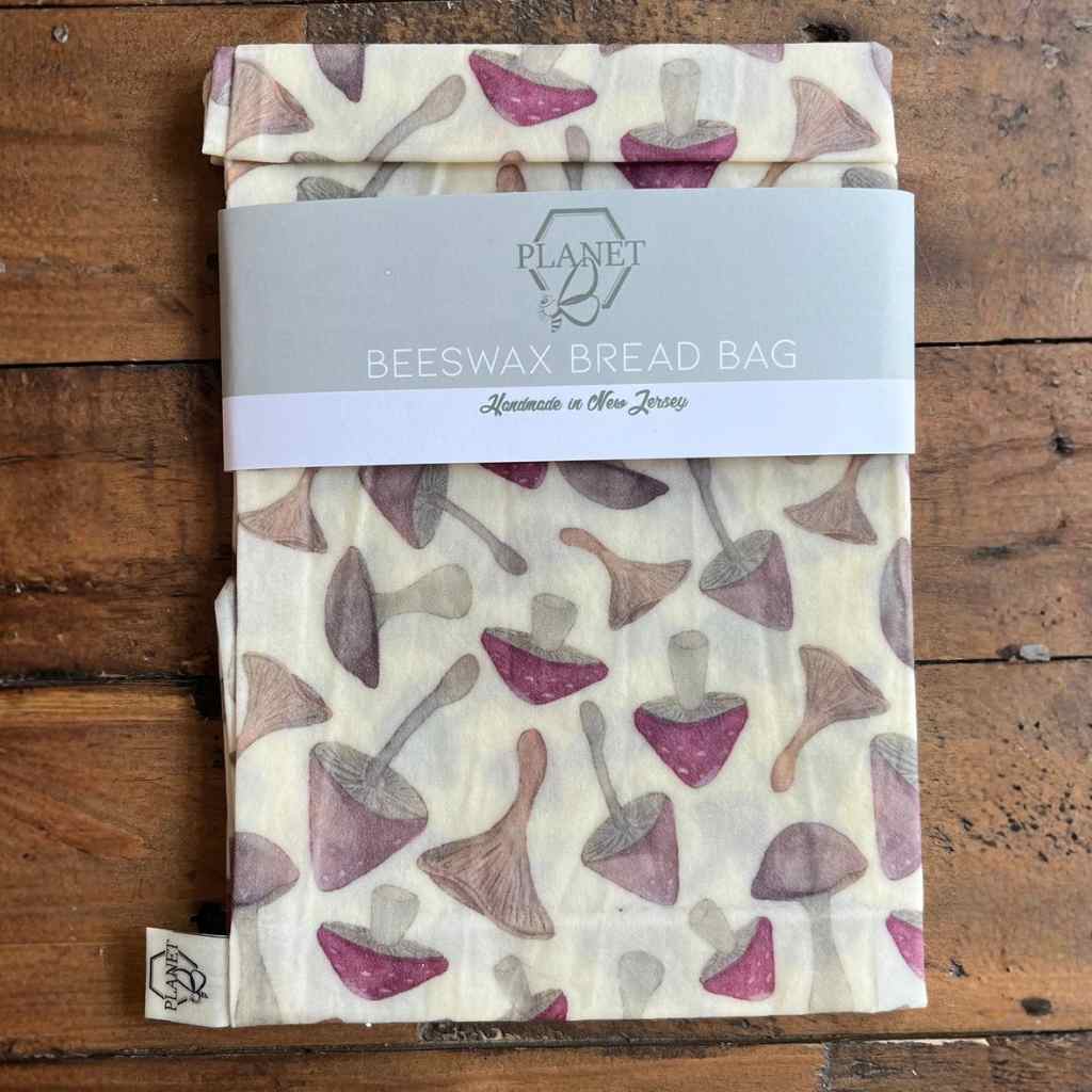 Beeswax bread bag with mushroom pattern on a wooden surface