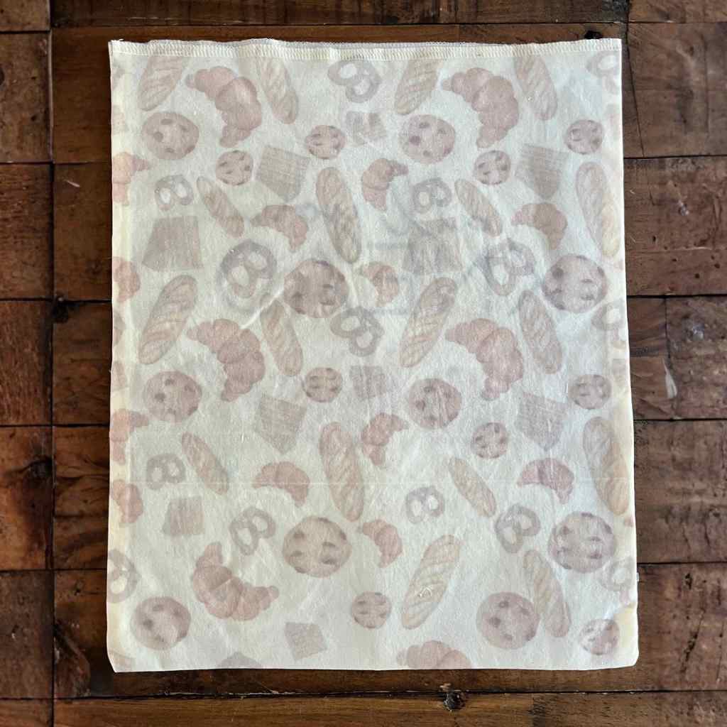 Bread bag back side featuring baked goods on rustic wood background.