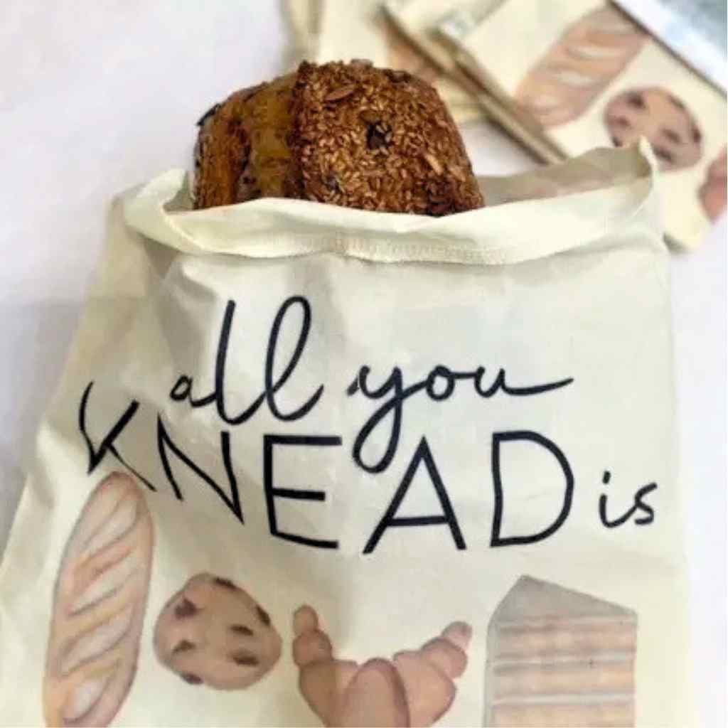 Bread bag with baked good illustrations and text 'all you KNEAD is' on a white background.