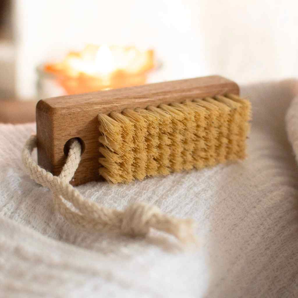 wood brush with sisal bristles on white fabric.