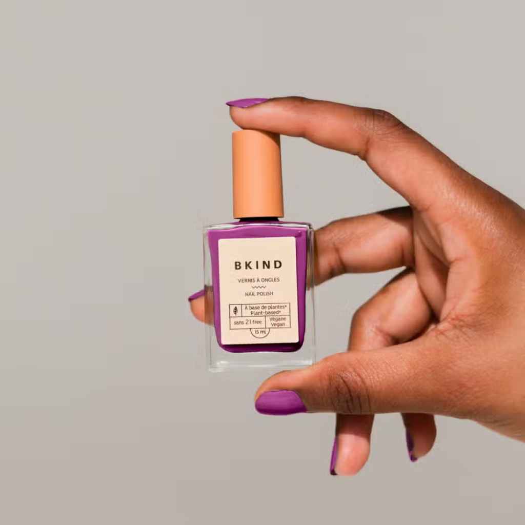 VEGAN, 21-Free, 77% plant-based nail polish, BKIND nail polish in Zodiac Aries - held by a woman's hand