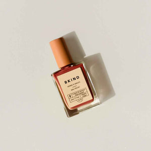 glass bottle of BKIND 3221-toxin free vegan nail polish in deep tomato red color called Leo