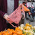 chili and natural striped market string bag being opened at market to put small pumpkins and gourds in