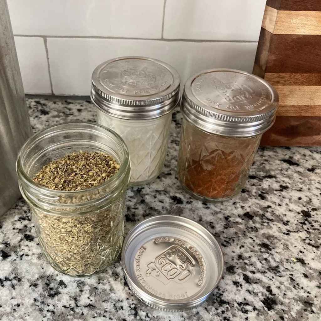three mason jars on a kitchen counter shown with one-piece stainless steel lids made by EcoJarz