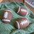 3 Friendsheep "game day" dryer balls (football shaped) on a green blanket