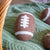 a single Friendsheep "game day" dryer ball (football shaped) on a green blanket