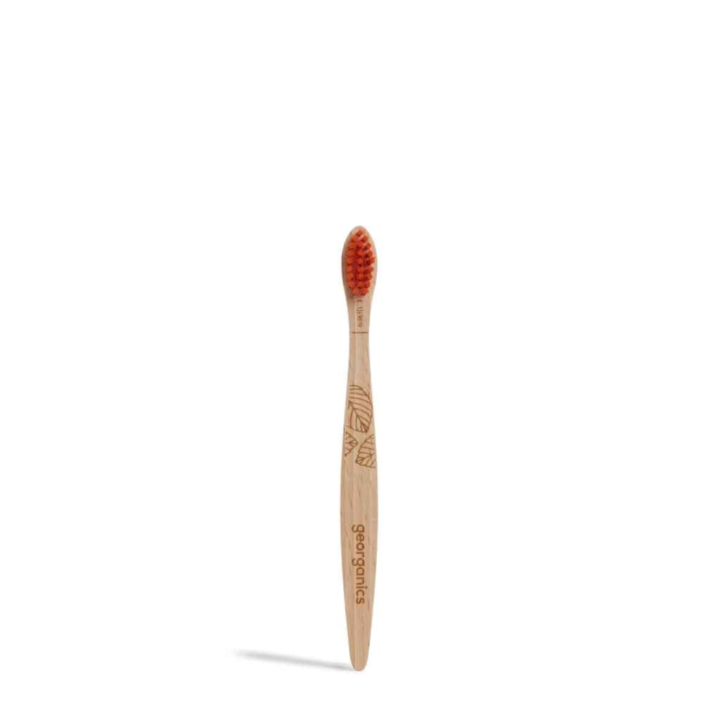 Front view of Georganics vegan toothbrush for kids with orange colored nylon bristles and a shorter handle
