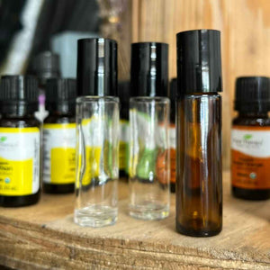 small glass bottles with black tops meant to be filled with essential oils