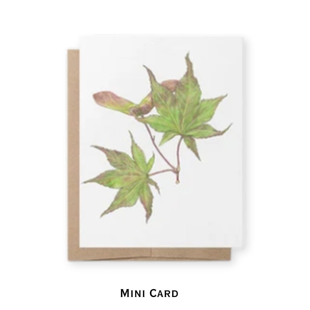 A mini greeting card with a watercolor illustration of green and brown maple leaves on a white cardstock, shown with a brown kraft envelope on a white background. The text 'MINI CARD' is printed below.