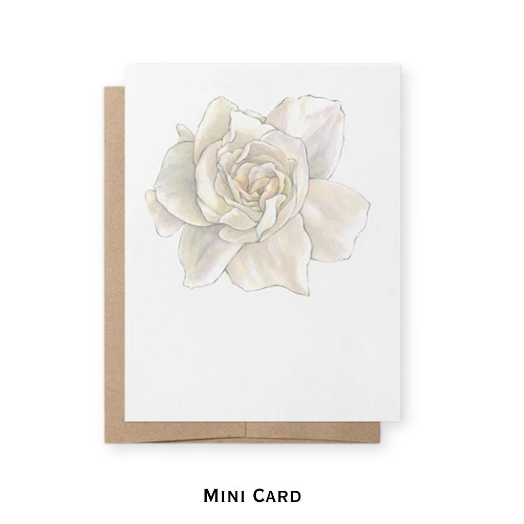 A mini greeting card with a white background featuring a delicate watercolor illustration of a white gardenia shown with a brown kraft envelope behind it on a white background. The text 'MINI CARD' is printed below.