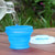 Collapsible reusable silicone travel cup and container - GoCup by humangear. 8oz. BPA-free, plastic-free.  Shown in blue with water being poured into it, with the lid off.
