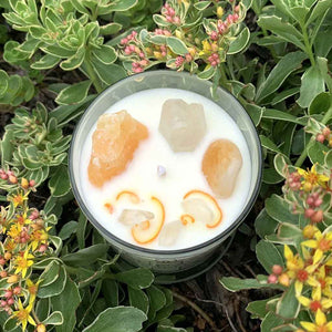Midheaven Crystal Intention Candles | Energy & AbundanceCrystal Intention Candles | Energy & Abundance - a white soy candle with white and orange crystals and a cotton wick sitting among yellow flowers