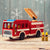 red handmade fire truck toy shown with figurines in different positions