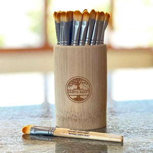 bamboo container filled with paint brushes made of bamboo, metal grip, and vegan bristles