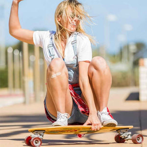Woman riding a skateboard while wearing a beige bamboo bandage on one knee.