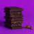 Seattle Chocolate - Dark Sea Salt Toffee Truffle Bar in pieces, stacked in a vertical pile to show contents, against a purple background