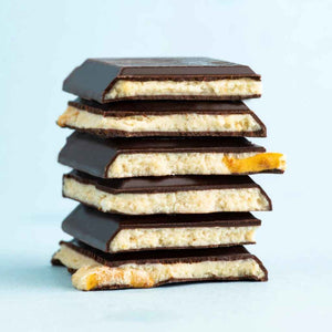 Seattle Chocolate - Peanut Butter Pretzel Truffle Bar, shown broken into stacked pieces to show white chocolate inside.