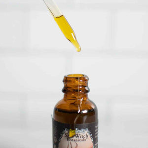 Tomte™ Beard & Hair Tonic in a small amber glass dropper bottle, pictured open with a drop of oil falling from the dropper top