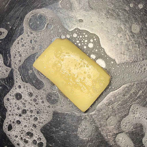 CANARY CLEAN All Natural Dish & Surface Soap - plant-based, plastic-free, made by Sea Witch Botanicals shown in suds in a stainless steel sink