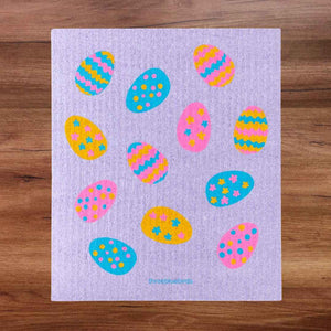 Purple Swedish Dishcloth with colorful pastel Easter Egg pattern against light purple background. Front Side Eco-Friendly