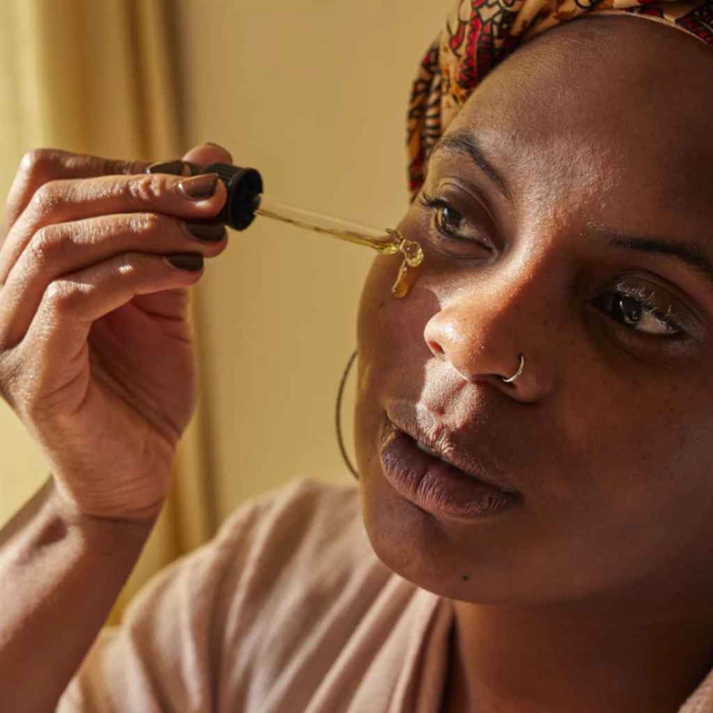 woman shown applying facial oil to cheek