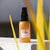 UpCircle Face Toner in travel size glass spray bottle, shown sitting outdoors