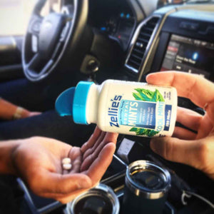 hands pouring mints out of a white bottle with blue cap of Zellie's Dental Mints sweetened with 100% Xylitol- COOL MINT flavor, 250 count