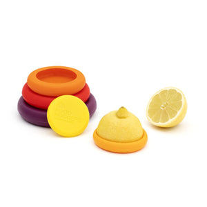 stack of multicolored food huggers, lemon halves with orange food hugger attached