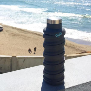 20 oz eco-bottle Midnight blue, outdoors on sunny beach, extended position