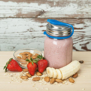almonds, strawberries, oats and banana slices surrounding mason jar filled with smoothie, eco jarz lid with blue pop top